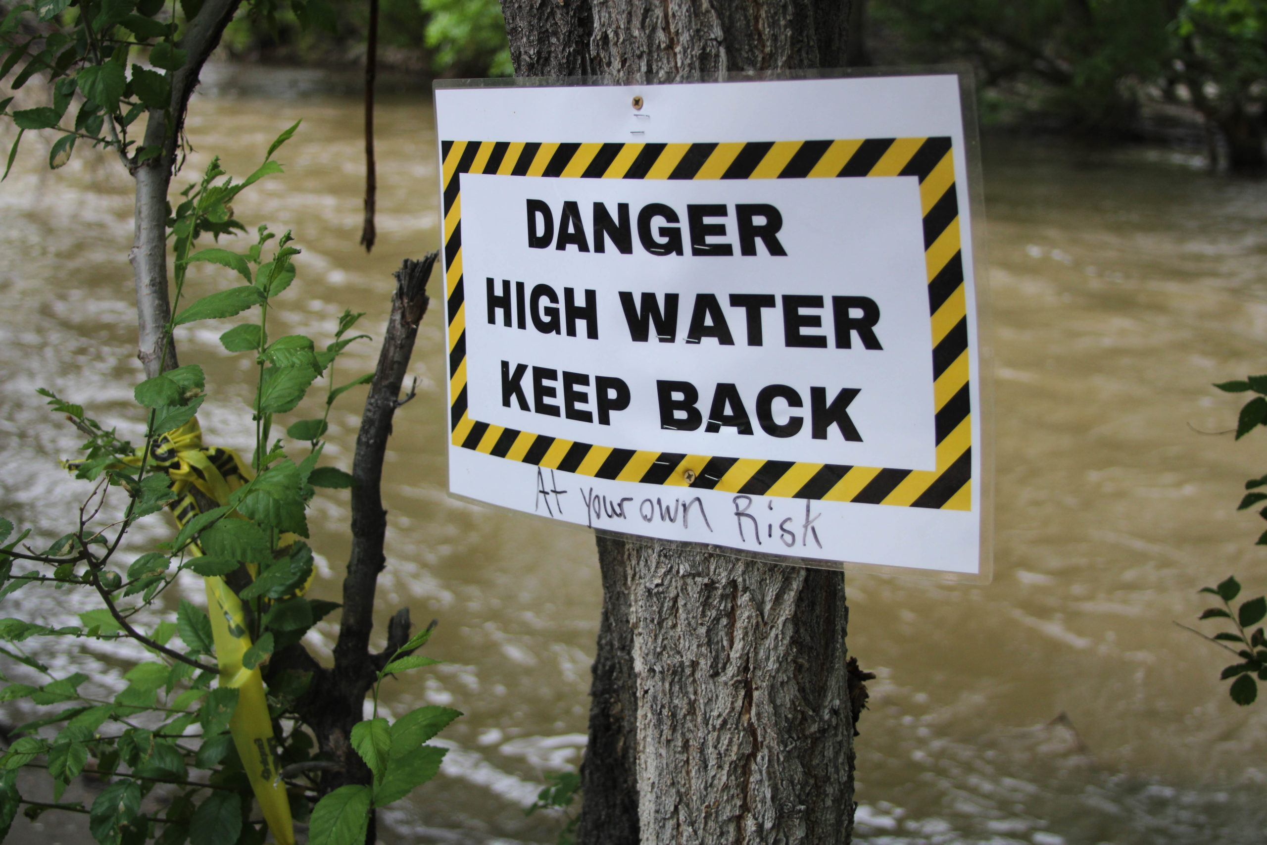Signs advising visitors to stay back from the rushing, high waters of the Ogden River.