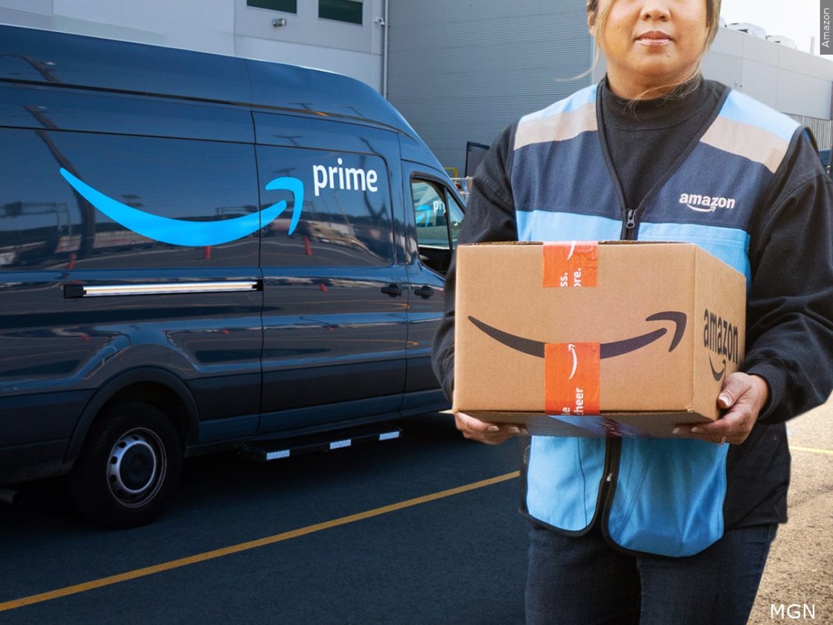 An Amozon delivery driver carrying a package near an Amazon Prime delivery van.
