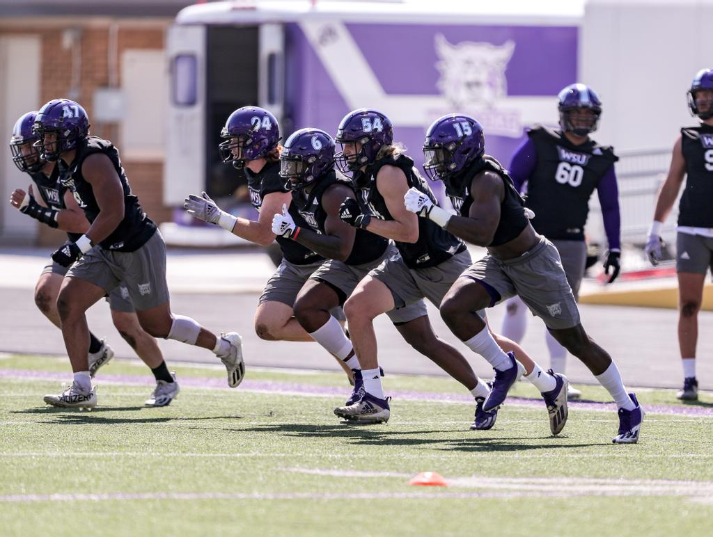 Weber State football players running across the field. Taken in August 2018.
