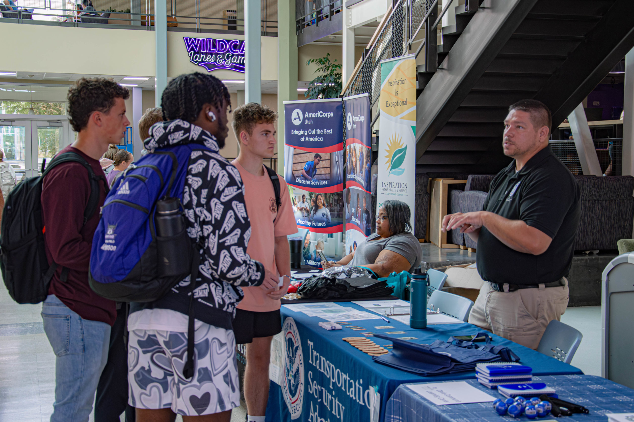 A group of students gather around the Transportation Security Administration booth to discover their services and benefits.
