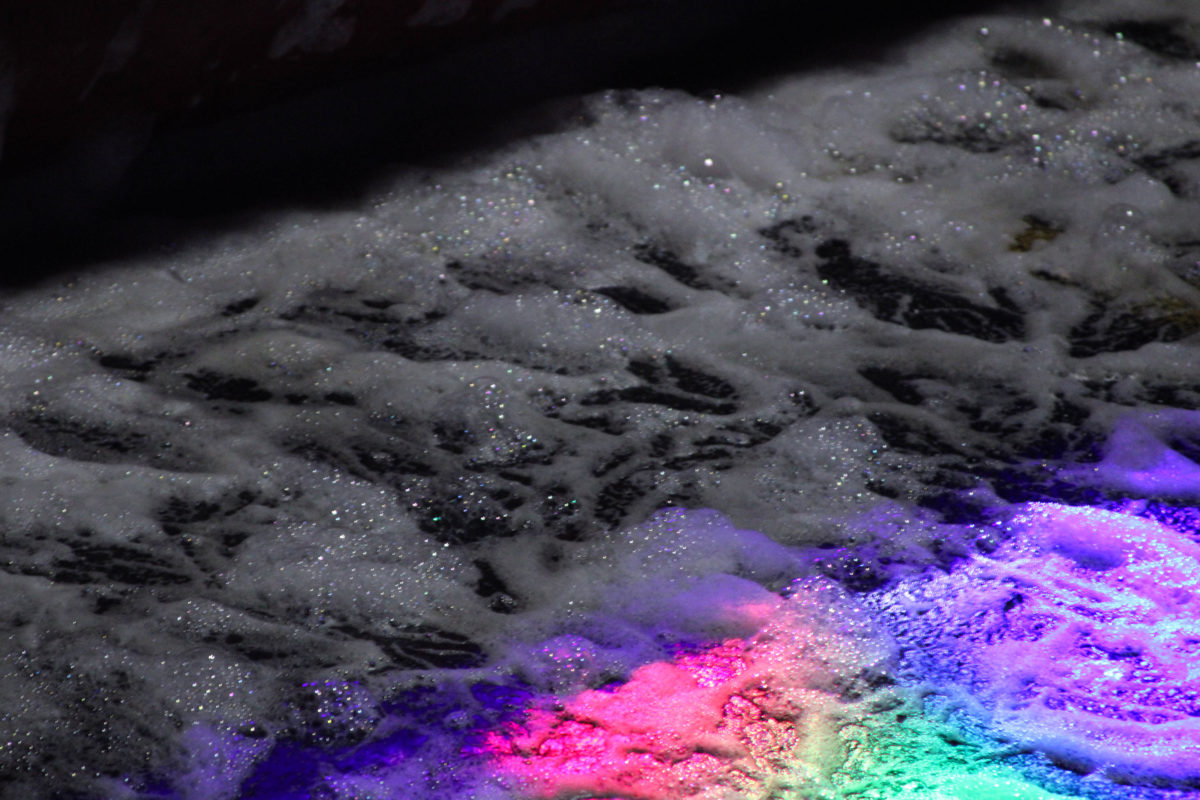 Neon strobe lights flashing over the foam pit.