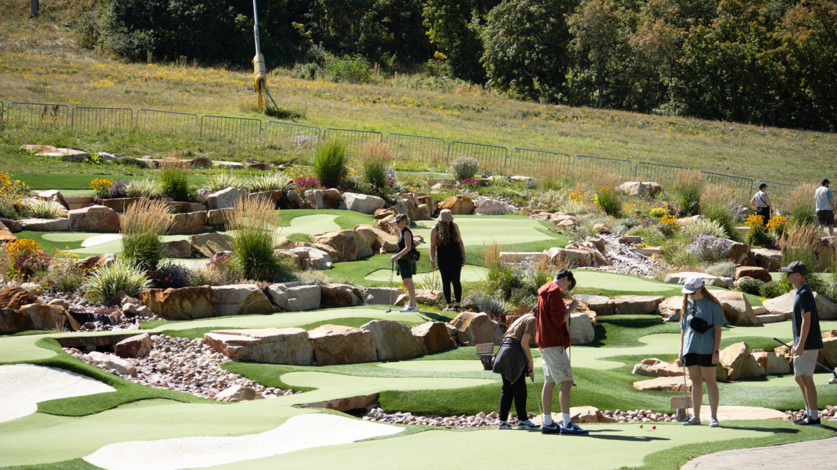 Attendees enjoy a game of miniature golf at the mini golf course at the Snowbasin resort.