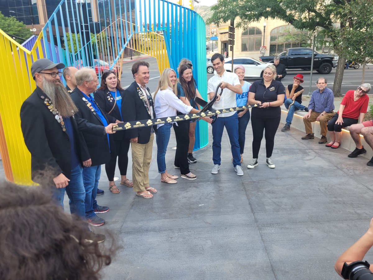 The artist and members of the local business community, cut the ribbon at the unveiling of a new art piece.