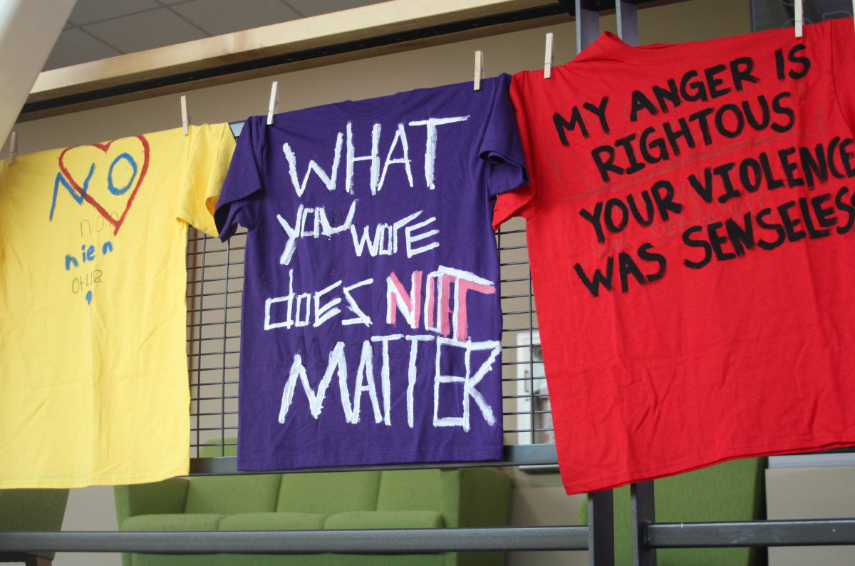T-shirts displaying messages against violence hang by clothespins in Shepard Union for the Clothesline Project.