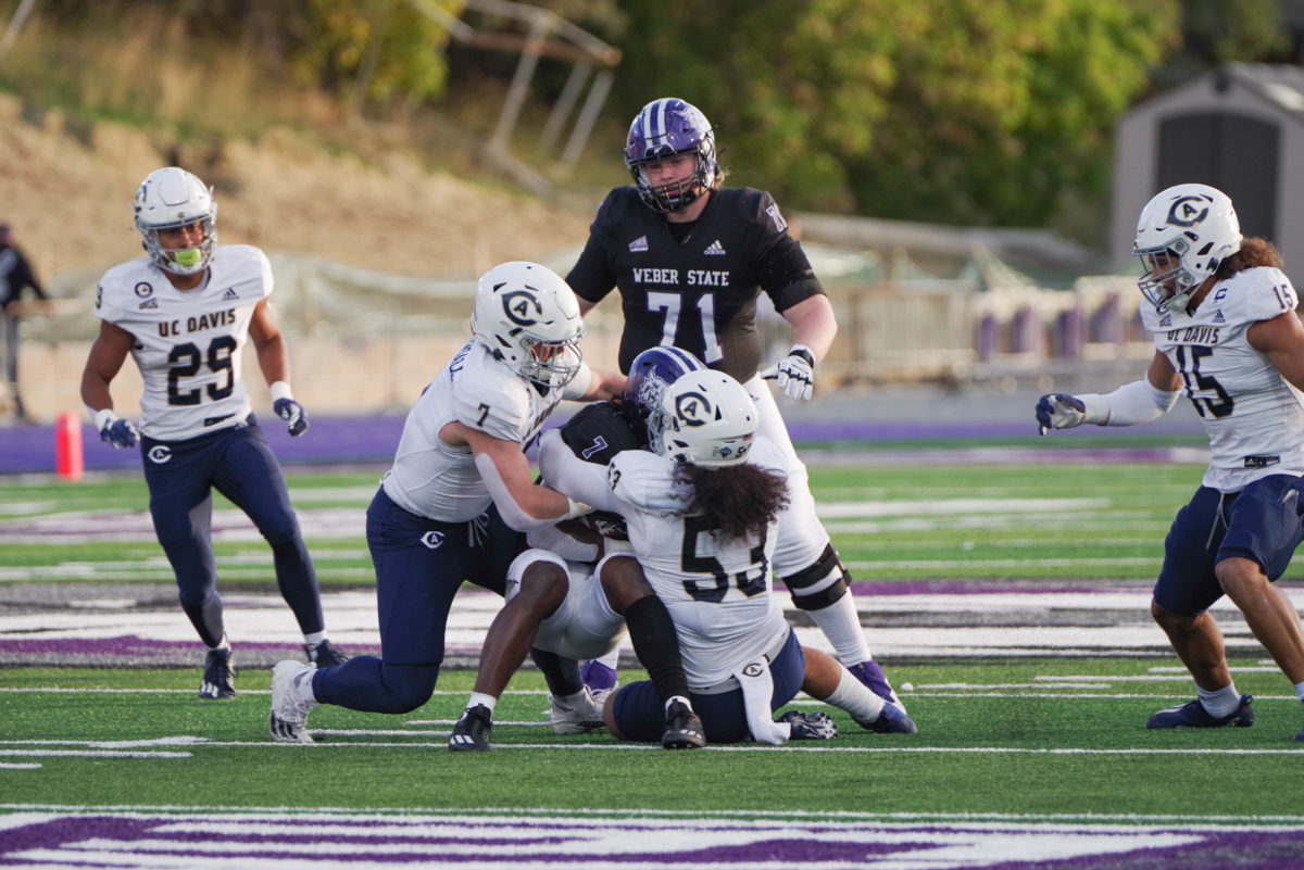 Weber State Runningback, Kris Jackson (7) being tackled by UC Davis.