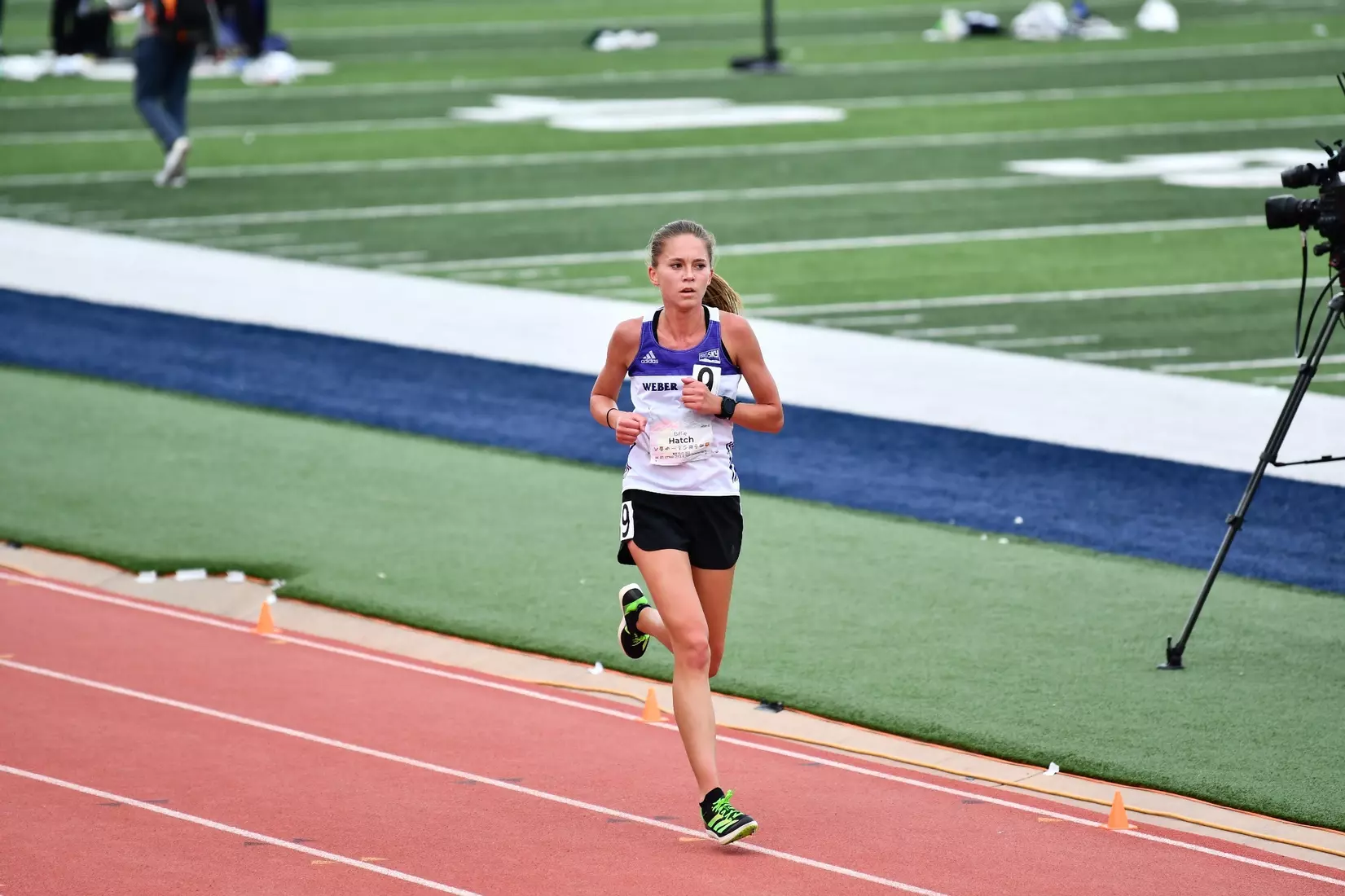 Distance runner Billie Hatch running on the track at a Womens Track and Field event.