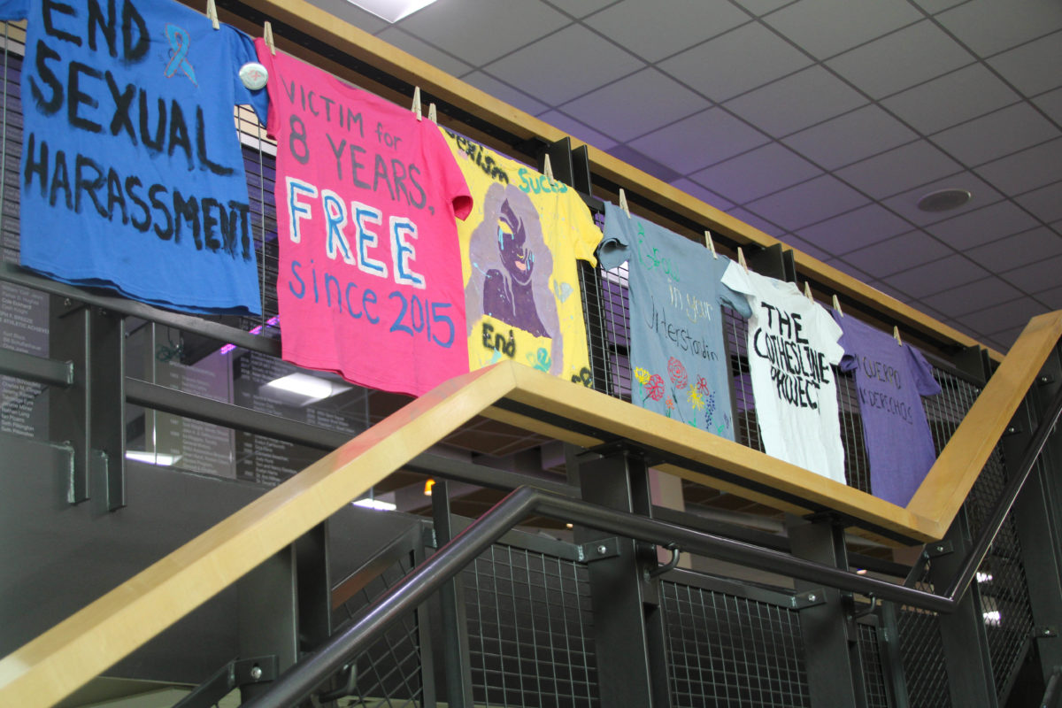 Shirts with designs made by domestic/sexual violence survivors hang alongside the staircase in Shepherd Union.