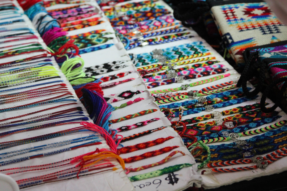 Woven bracelets laid out across a vendors booth.
