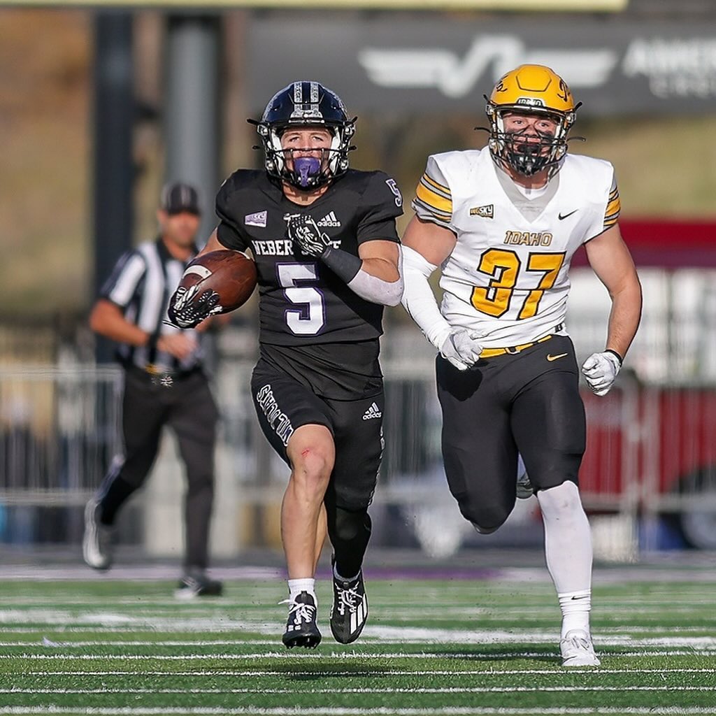 Weber State University wide receiver, Haze Hadley (5) running down the field with the football as a University of Idaho player runs after him.
