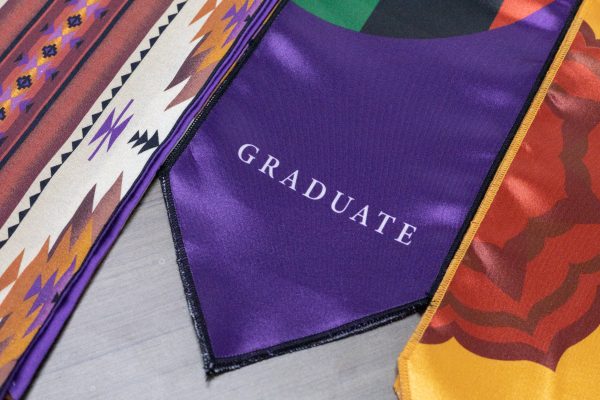 The word graduate written on the African Diaspora stole.

La palabra graduar escrita en la estola de diáspora africana.