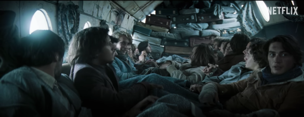A screen grab of the Old Christian Rugby team huddled together in the plane wreckage to keep warm.