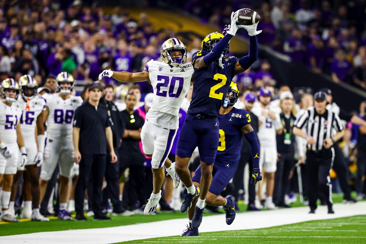 Michigan defensive back Will Johnson intercepts the pass to Washington running back Tybo Rogers at the start of the second half as the Michigan Wolverines play the Washington Huskies in the CFP National Championship Monday, January 8, 2024 at NRG Stadium in Houston.