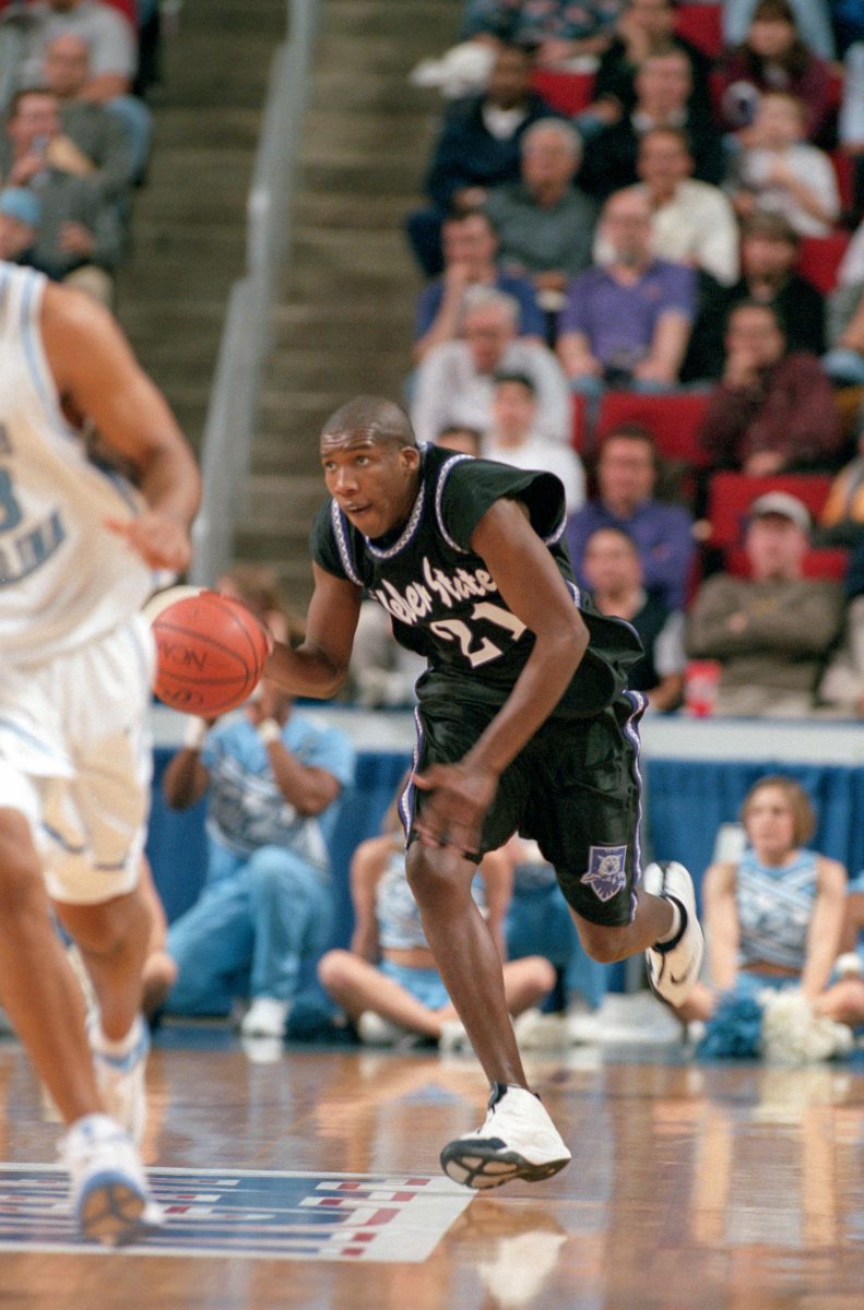 1999 Weber State University Mens Basketball Forward, Harold Arceneaux (21) dribbling the ball down the court.