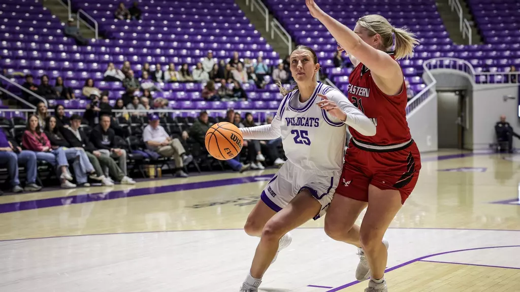 Weber State Womens Basketball Forward position, Taylor Smith (25), dribbling the ball down the court while avoiding an opposing team member.