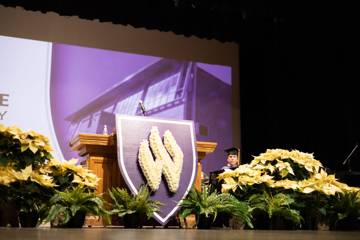 The Weber State University W decorates a stand for speakers in the fall 2023 graduation.