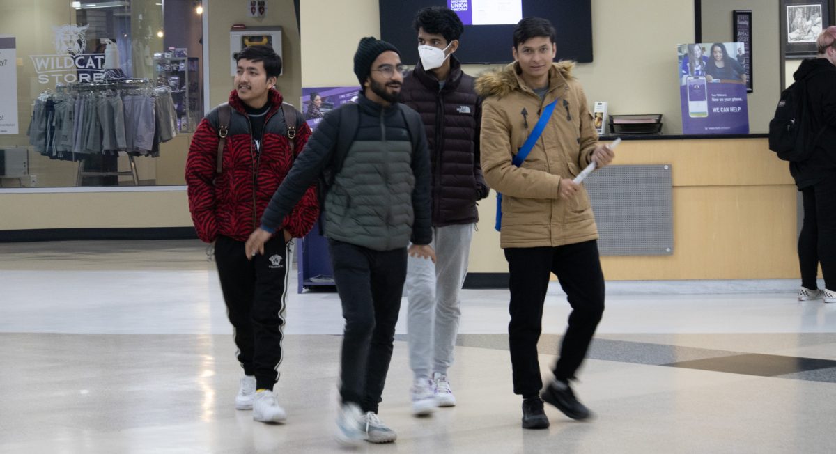 A group of students walk through Shepard Union together.