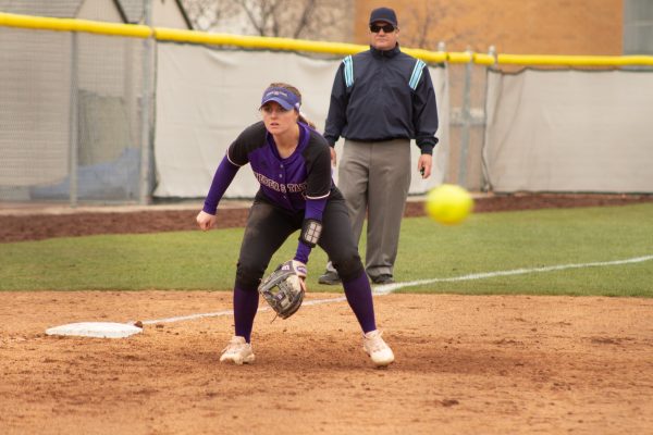 Emily Ruhl and a referee watches the batter as the pitched ball flies past her during the April 2022 softball season.