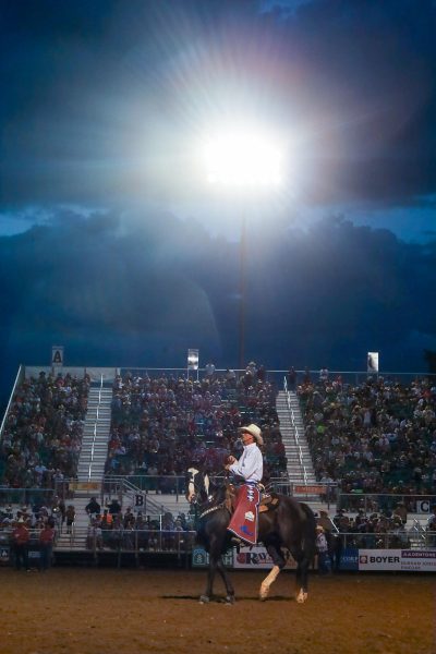 A horseback rider on the back of his horse riding across the Ogden Pioneer Days rodeo arena.