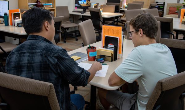 Charlie Vasquez (left) gives constructive feedback to Wyatt Jacobson (right) on an English paper at the Tutoring Center.