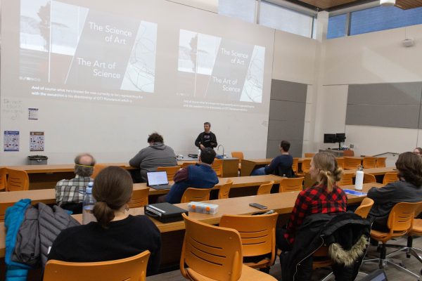 A Weber State University Physics Professor Adam Johnston introducing John Armstrong, the director of the planetarium at WSU's Ogden campus at a lecture.