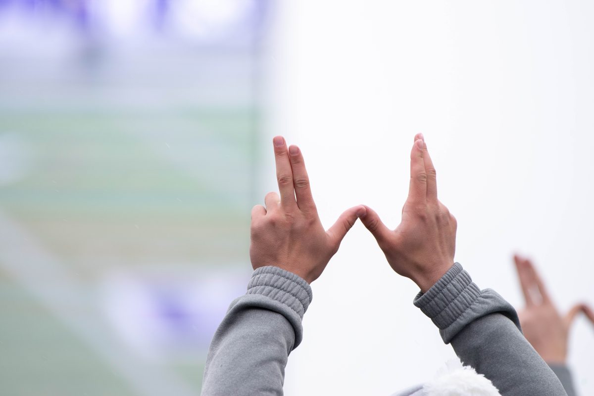 A Weber State cheerleader holding up a W in support of the football team.