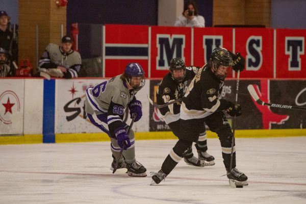 Jack Jones, a Weber State hockey player, attempting to get possesion of the puck from the other team. 