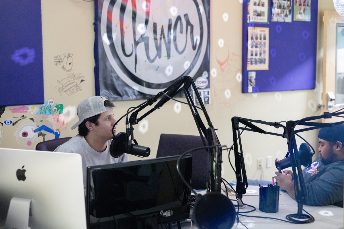 KWCR Trevin Johnson and KWCR Sports Director Grayden Guthrie working on a script together.