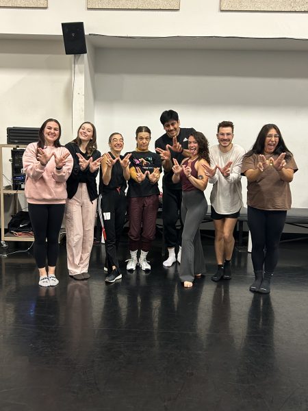 Weber State University dancers throwing up the school's W sign at rehearsals.