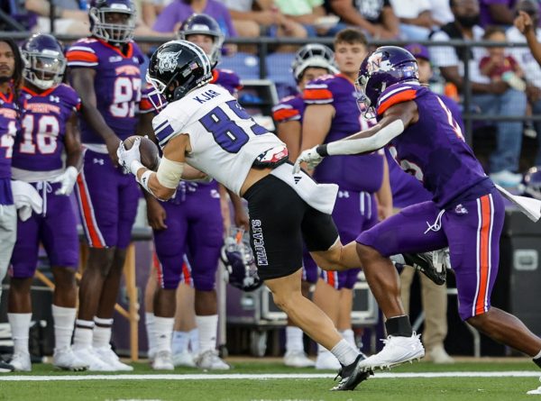 Weber State Wide Receiver, Noah Kjar (#89), being tackled with the ball by an  opposing Northwestern State player.