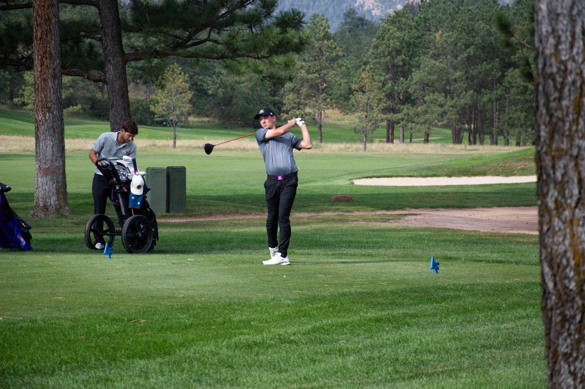 Weber State Men's Golfer, Hayden Banz, watching the distance on the ball after making a swing.