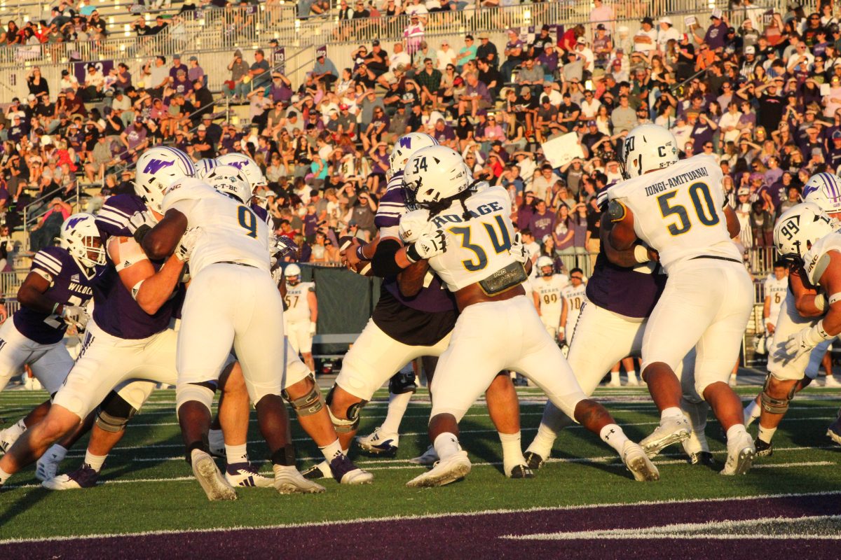 Quarterback Richie Munoz (10) hands the ball off to Running back Davion Godley (27).