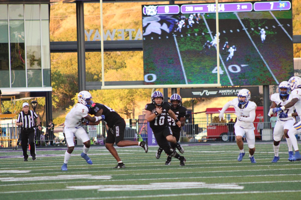 Weber State Quarterback, Richie Munoz (#10), running down the field with the ball as McNeese players go after him.