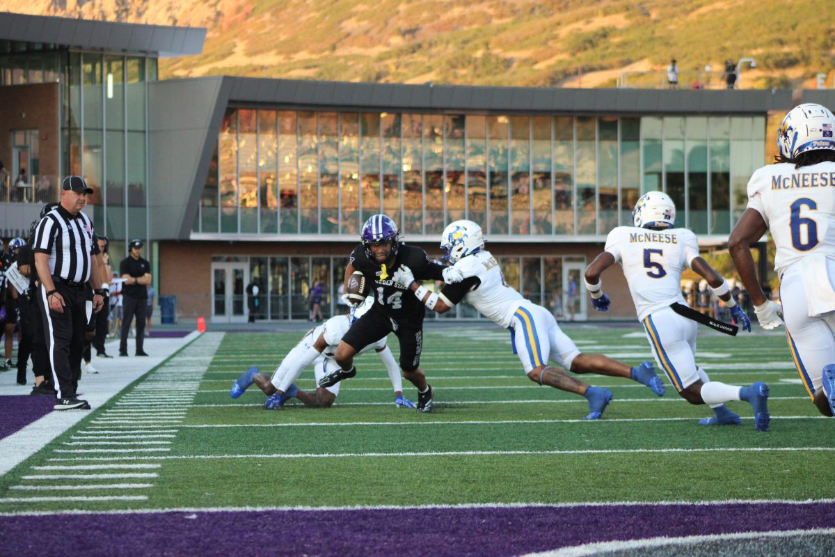 Weber State Wide Receiver, Jacob Sharp (#14), making a break for it as McNeese players try to tackle him.