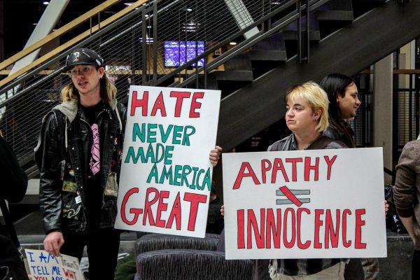 Members of the WSU Democrats, Tessie Violet (left) and Jude Dougall (right) hold up handcrafted posters during their protest.