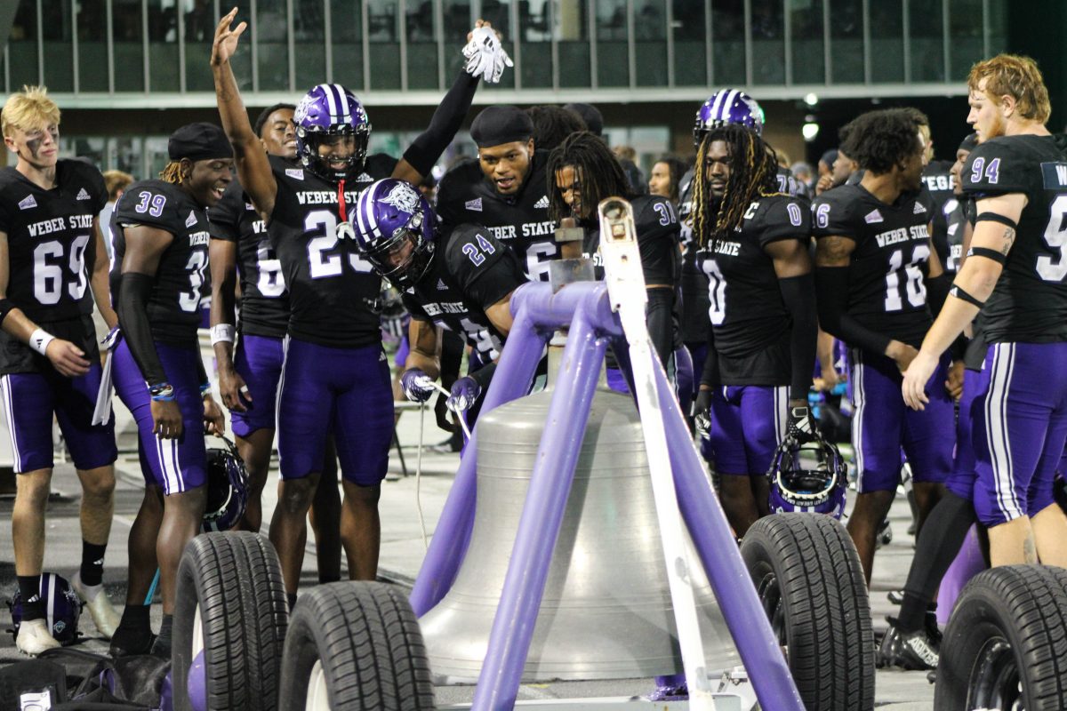 Weber State football players gather around the victory bell after defeating Portland State at Weber State University's first home game on Sept. 7.