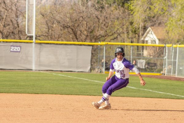 Katelyn Whiting starting to run to the next base after one of her teammates hits a softball while batting.