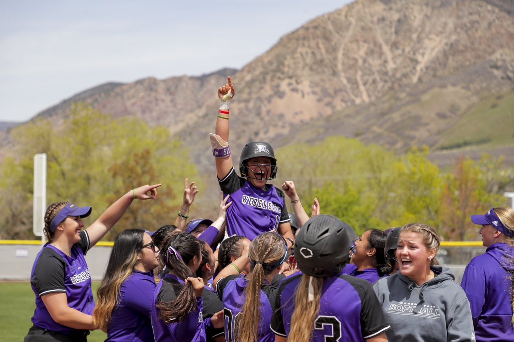 Weber State University softball team celebrating with one another.