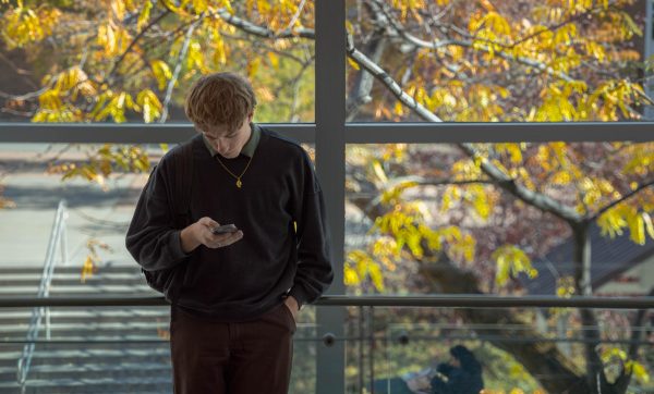 Karter Merrill scrolls through their social as they await for their upcoming class.// Karter Merrill Usa las redes sociales en lo qua espera por su siguiente clase.