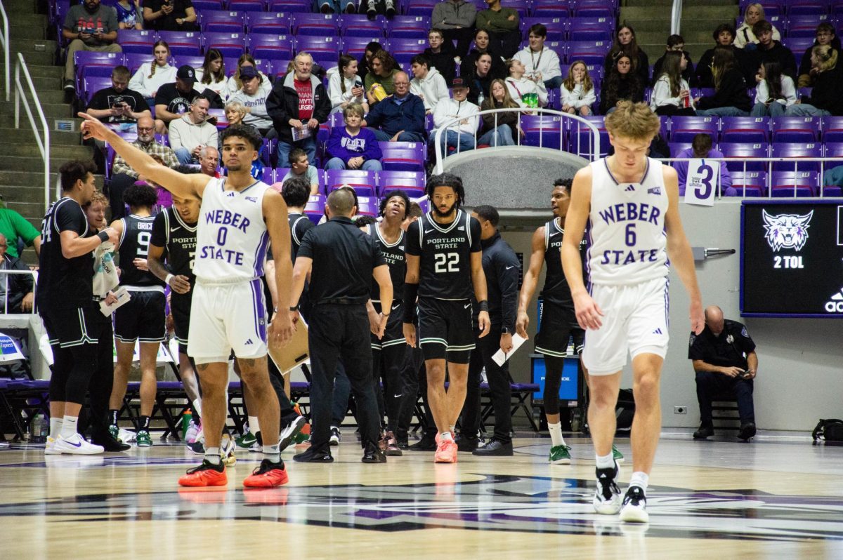 Weber State Guards Blaise Threatt (#0), and Trevor Hennig (#6) walking along the court.// Guardia de Weber State Blaise Threatt (#0), y Trevor Hennig (#6) caminando por la cancha.