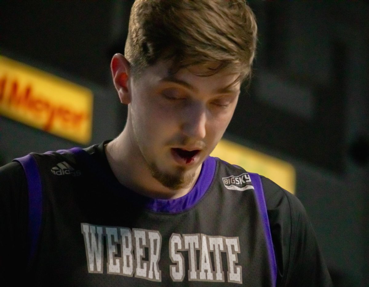 Weber State University Center, Vasilije Vucinic (#13), walks off the court after getting hit in the mouth.