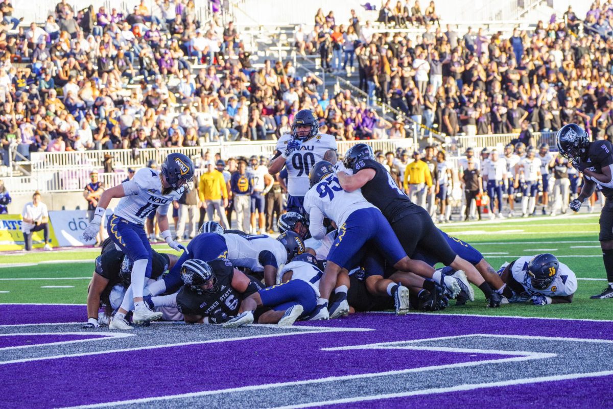 Pile-up at a football game against NAU. // Una pila de jugadores en uno de los juegos de football en contra de NAU.