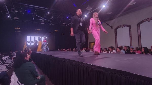The fashion designers leading all of the models together down the runway.// Los diseñadores de moda guiando a todos los modelos bajo la pista.