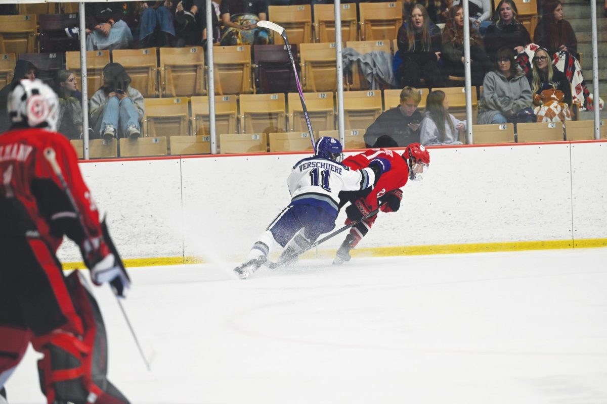 Weber State University hockey forward Simon Verschuere (#11) tries to get the puck from a University of Utah defenseman.