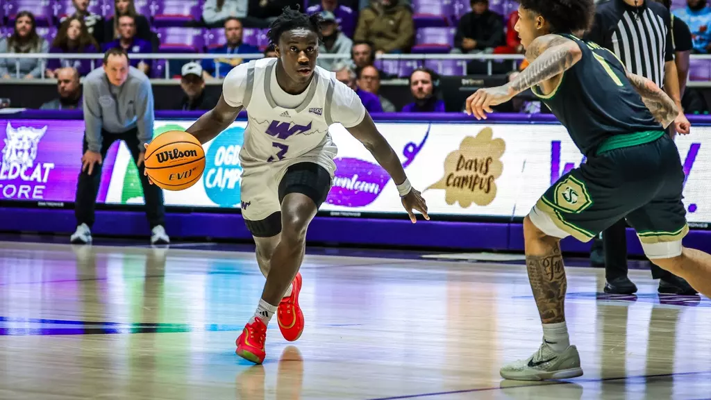 Weber State University men's basketball Tijan Saine Jr. (#3), dribbles the ball away from a Northern Arizona University player.

El jugador de baloncesto masculino de Weber State Tijan Saine Jr. (n.º 3), regatea a un jugador de la Universidad del Norte de Arizona.