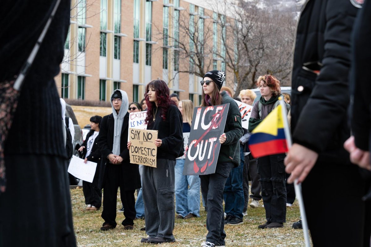 Weber State University students hold up protest posters against I.C.E. as well as flags representing their families' native countries in support of their immigrant ties on Feb. 17, 2026. // Estudiantes de la Universidad de Weber State sostienen carteles de protesta contra el Servicio de Inmigración y Control de Aduanas (ICE) y banderas que representan los países de origen de sus familias en apoyo a sus lazos inmigrantes el 17 de febrero de 2026.