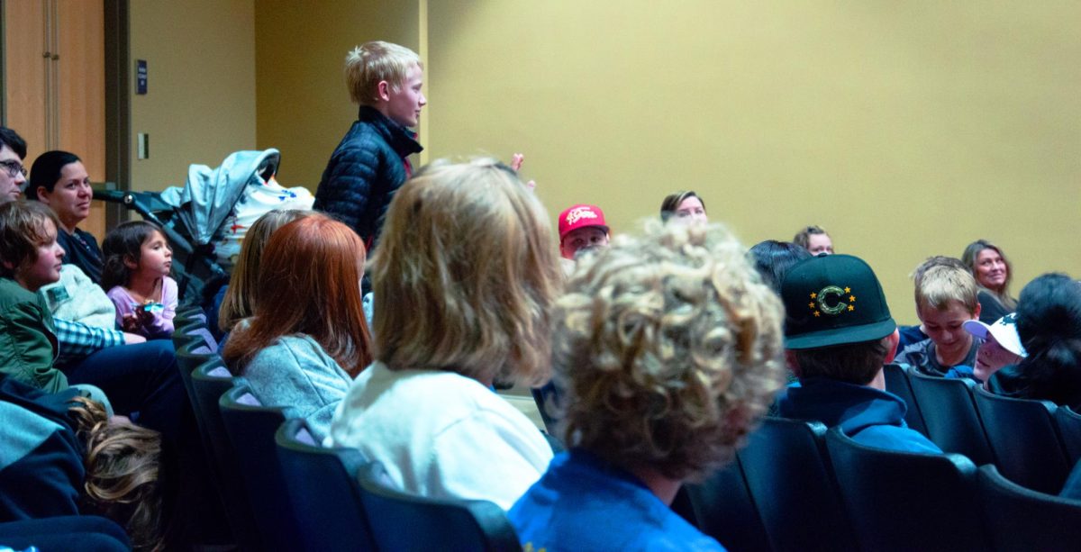 A student in attendance stands to ask a storyteller a question at the Weber State University Storytelling Festival on March 12, 2026.// Un estudiante del público se levanta para preguntarle a un narrador por qué eligió las historias que contó en el Festival de Narración de la Universidad de Weber State, celebrado el 12 de marzo de 2026.