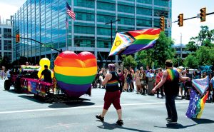 Parade marchers wave Pride flags during the parade route on June 7, 2026.