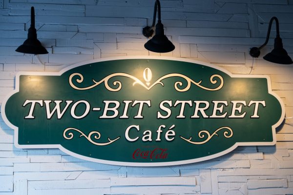 The Two-Bit Street Cafe sign displayed on the wall inside of the Two-Bit Bistro. // El letrero del Two-Bit Street Cafe que se muestra en la pared dentro de Two-Bit Bistro.